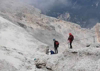 Ferrata Cristallo Dolomite mountains day excursion, a route equipped with metal cables, ladders, and other fixed anchors as wooden walkways and suspension bridges.